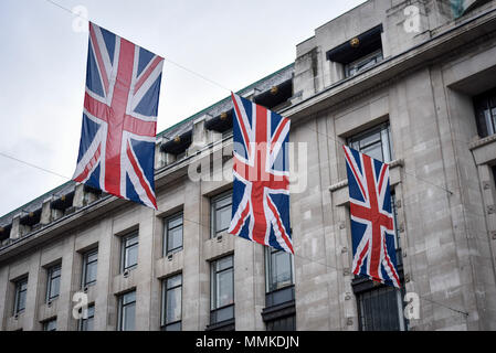 London, UK. 12 May 2018.  UK Weather - Union flags decorate Regent Street in the rain ahead of the Royal wedding of Prince Harry and Meghan Markle taking place on 19 May 2018.  Credit: Stephen Chung / Alamy Live News Stock Photo