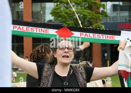 Manchester, UK. 12th May 2018. A Pro Palestinian campaigner holds up a scarf with 'Palestine' written on it at a camp for Nakba Day which commemorates the displacement of Palestinians  in 1948, when the Israeli state was founded.  Nakba, is an Arabic word meaning 'disaster'.  Piccadilly Gardens, Manchester,12th May, 2018 (C)Barbara Cook/Alamy Live News Stock Photo