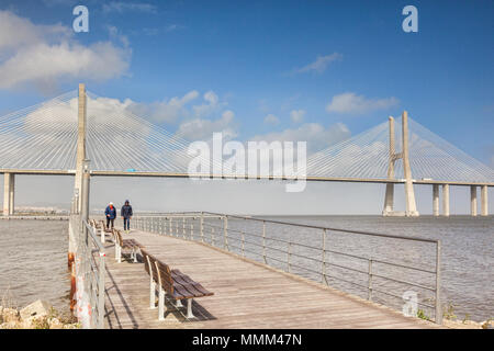 2 March 2018: Lisbon, Portugal - Two men out for a walk on the boardwalk near Vasco da Gama Bridge, the 17km cable stayed bridge which spans the River Stock Photo