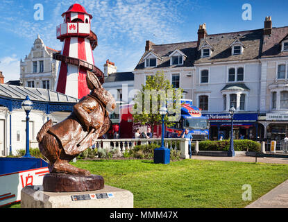 7 May 2018: Llandudno, Conwy, North Wales - White Rabbit oak sculpture, by Simon Hedger, part of the Alice in Wonderland Trail, with some of the attra Stock Photo