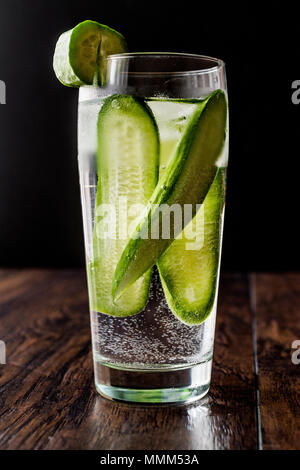 Cucumber Cocktail with vodka and tonic on dark wooden surface. Beverage Concept. Stock Photo