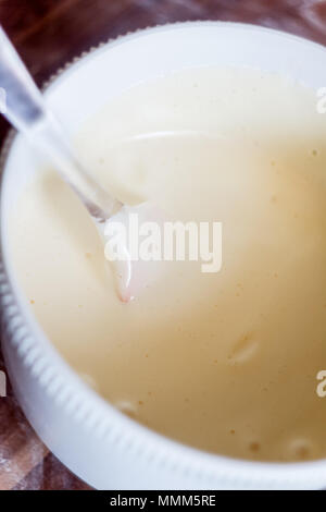 Close up of spatula and whipped cream in bowl on table. Stock Photo
