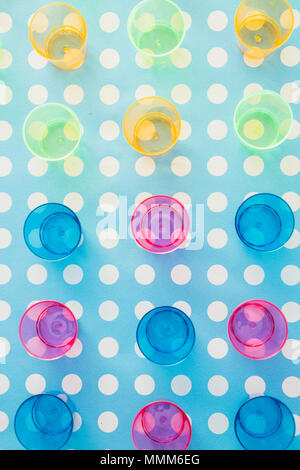 Colored party small tequila glass over a pois white blue background Stock Photo