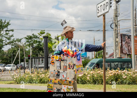 CHISHINAU, MOLDOVA - June 11, 2017: A street vendor waits for the cars to stop. In Chisinau, street vendors offer drivers their goods when the cars ar Stock Photo