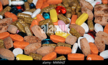 A mix of pills containing prescribed medicines and dietary supplements Stock Photo