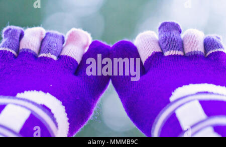 Purple socks with separate toes on a green background Stock Photo