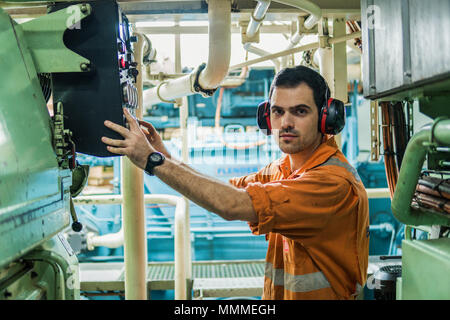 Marine engineer inspecting ship's engine in engine control room ECR. Seamen's work. Stock Photo