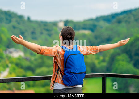 woman tourist with arms outstretched enjoys freedom in nature Stock Photo