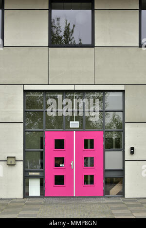 Bright pink door in a gray building Stock Photo