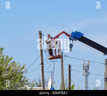 Slavyansk-on-Kuban, Russia - 24 April, 2018: Electricians repair the power line. Workers are locksmith electricians. Stock Photo