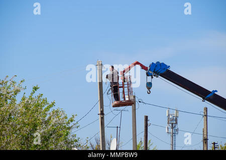 Slavyansk-on-Kuban, Russia - 24 April, 2018: Electricians repair the power line. Workers are locksmith electricians. Stock Photo