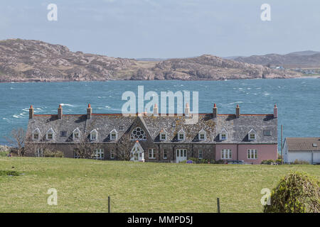 Houses near Iona Abbey on the Isle of Iona, Argyll and Bute on the Inner Hebrides, Scotland, UK with the Isle of Mull and Fionnphort in the background Stock Photo