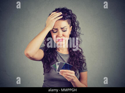 Confused stressed woman looking at too many credit cards Stock Photo