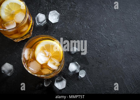 Whiskey High Ball Cocktail with lemon and ice cubes on black background, copy space. Stock Photo
