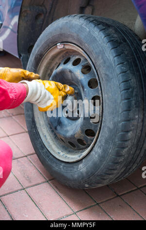 mechanic changing wheel on car Stock Photo