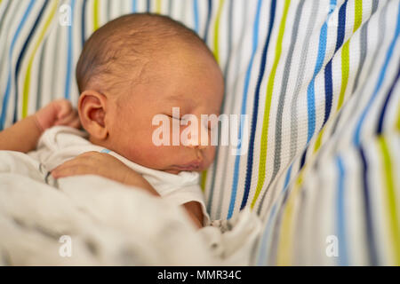 A newborn infant laying on a pillow sleeping with shallow depth of field Stock Photo