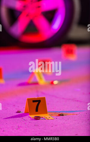 A shell casing is marked with an evidence marker within a crime scene ...