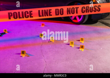 Cordon tape, marking a police line, is stretched in front of a crime scene. Stock Photo