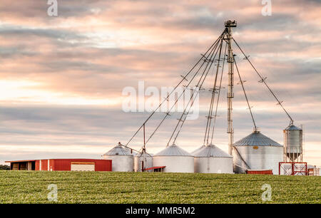 A view at sunset of steel grain silos on a farm in New Jersey off of route 40 in Maryland Stock Photo