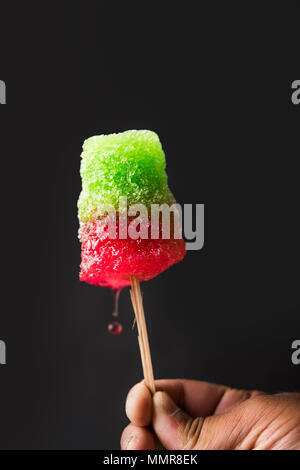 Chuski Or Baraf ka Gola also known as Ice candy, popular roadside refreshment in Indian summerin kala khatta, orange and mixed flavour Stock Photo