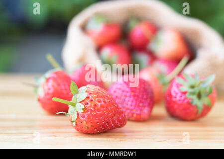 straw berry on wood table with sack background Stock Photo