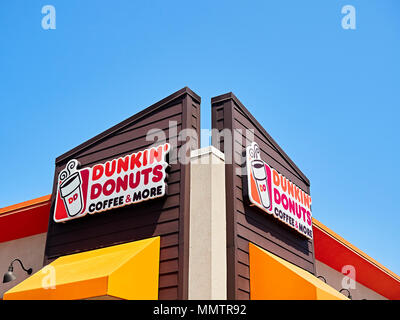 Dunkin Donuts fast food restaurant exterior sign with corporate logo. Stock Photo