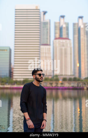 Young handsome Indian man thinking while wearing sunglasses agai Stock Photo