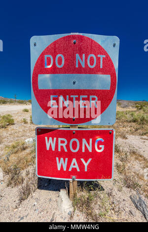 Bright Red sign warns drivers not to enter this lane of highway, Interstate 15, in desert outside of Las Vegas - WARNING - WRONG WAY!, Nevada Stock Photo