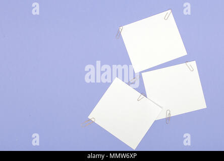Blank note papers label with clip on purple background. Stock Photo