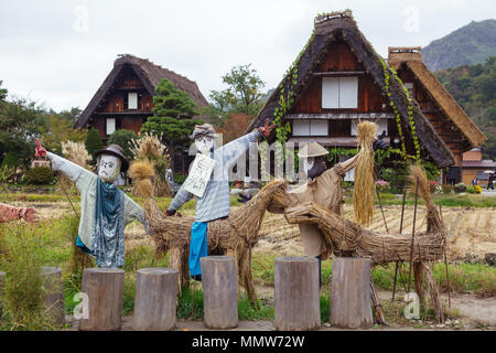 Scarecrows in front of traditional wooden houses in Shirakawa-go village, Japan Stock Photo