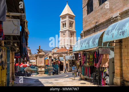 Small square with fountain among gift shops and tall belfry on background in Muristan, Jerusalem. Stock Photo