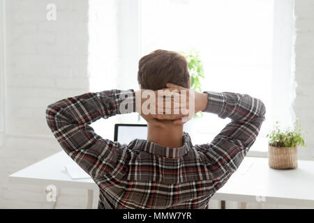 Rear view at relaxed man resting from work on laptop Stock Photo