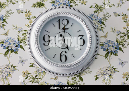 Round elegant white wall clock, five o'clock in the evening, interior details in Provence style Stock Photo