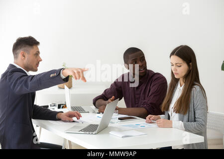 Rude multiracial businessmen humiliating firing female colleague Stock Photo
