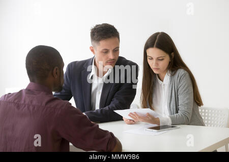 Serious caucasian hr managers attentively reading resume of afri Stock Photo