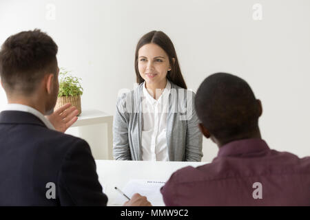 Confident applicant smiling at job interview with diverse hr man Stock Photo
