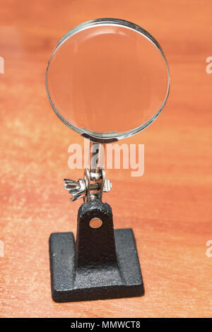 Magnifier on a stand on wooden table Stock Photo