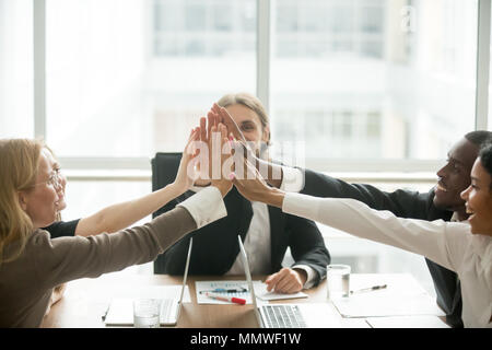 Excited happy multiracial business team giving high-five at offi Stock Photo