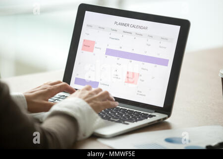 Businesswoman planning day using digital calendar on laptop, clo Stock Photo
