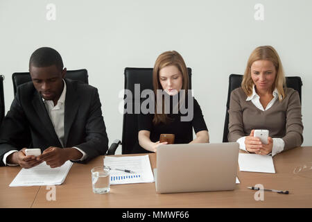 Multiracial business people holding using mobile phones at group Stock Photo