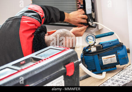 Technician vacuum pump evacuates and checking new air conditioner. Stock Photo