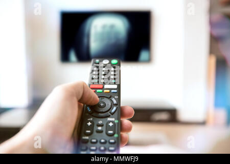 Human hand holds a remote control for a modern television Stock Photo