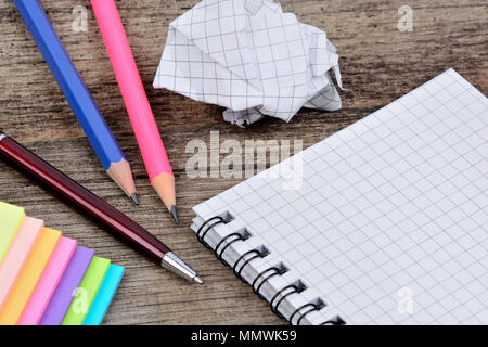 Empty notepad with pencils anc colorful notes on wooden table Stock Photo