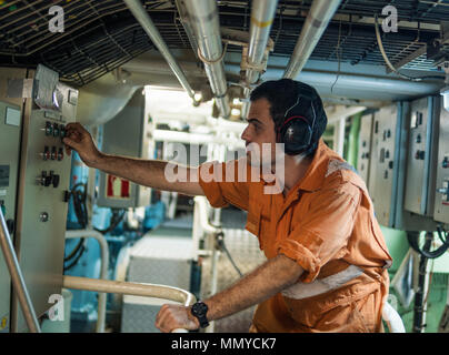 Marine engineer inspecting ship's engine in engine control room ECR. Seamen's work. Stock Photo