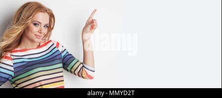 Portrait of cute girl colorful rainbow blouse pointing to the side to empty copy space Stock Photo