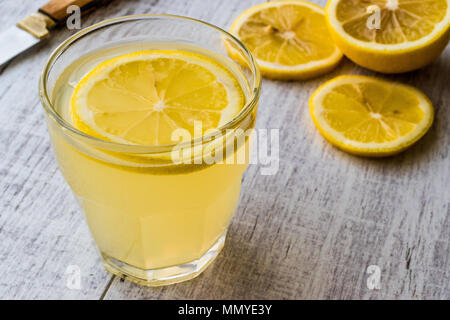 Lemon Liqueur Limoncello with lemon on white wooden surface. Beverage Concept. Stock Photo