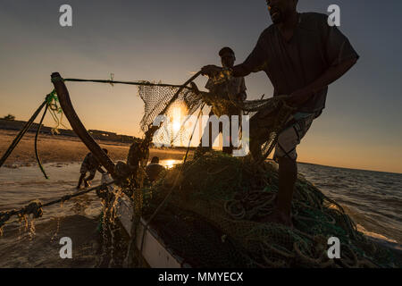 Local fishermen in Inhassoro Mozambique pulling in nets. Stock Photo