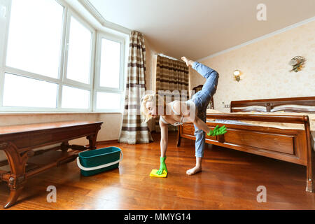 Woman cleans up the apartment, she washes floors and does a sports warm-up. Stock Photo