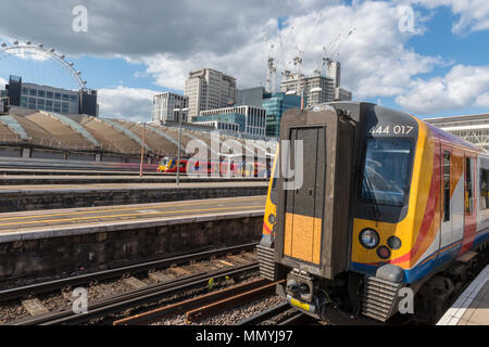 A south western railway train in a platform at london waterloo station with the london eye and new construction behind. Railways and trains commuting. Stock Photo