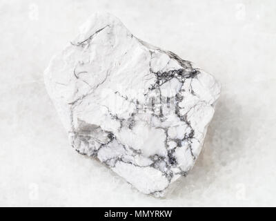 macro shooting of natural rock specimen - raw Howlite stone on white marble background Stock Photo